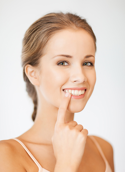 girl smiling pointing to her teeth