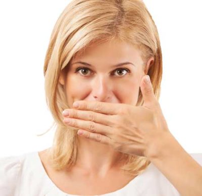 woman covering her mouth because of bad breath